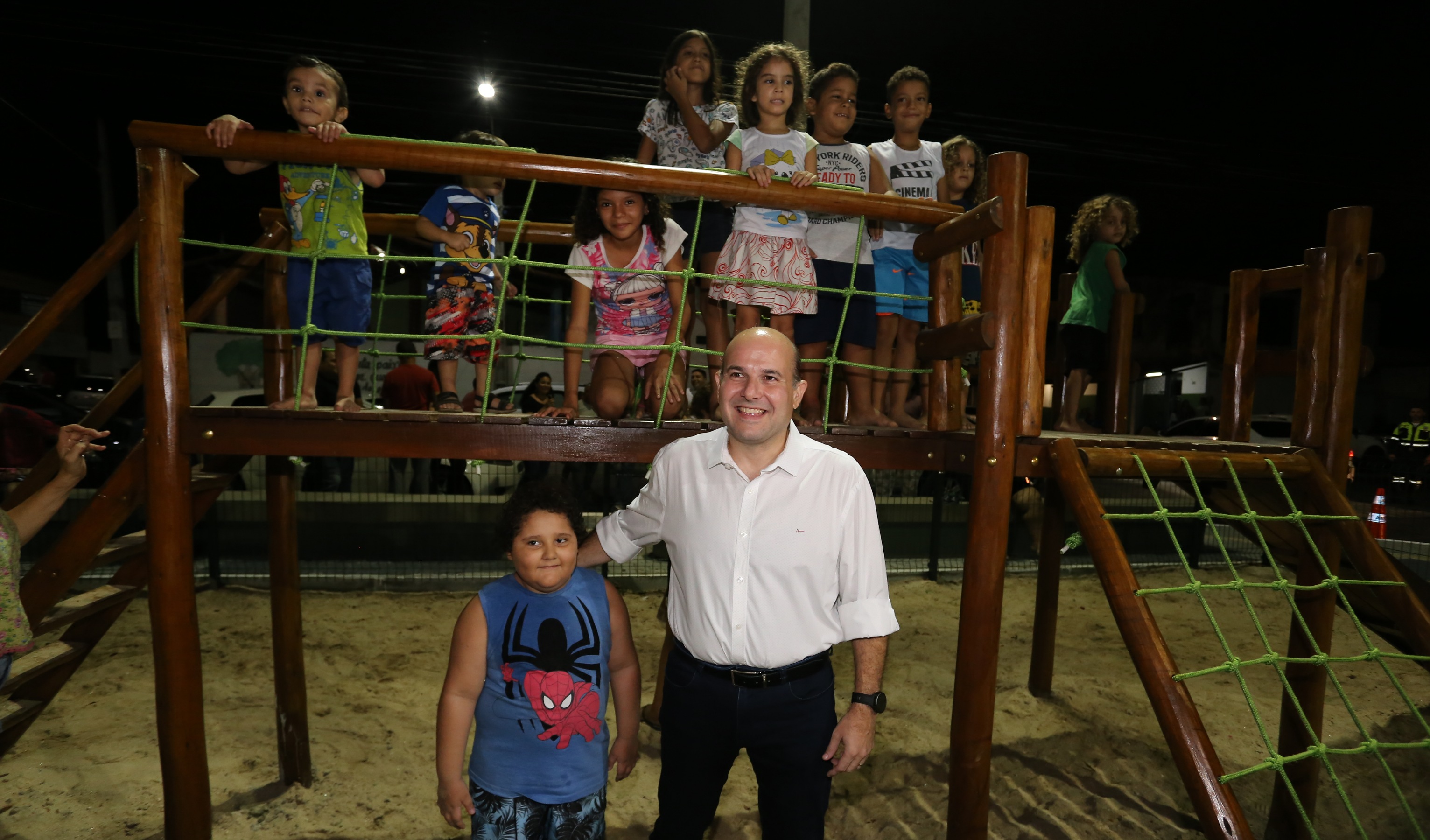 prefeito posando para a foto com crianças sorrindo em parquinho
